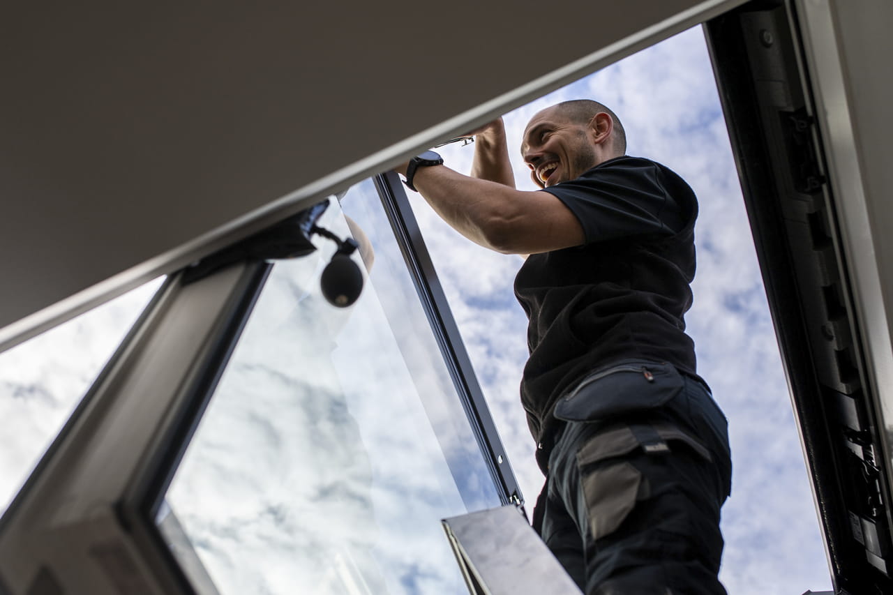 An installer making measurements on the roof.