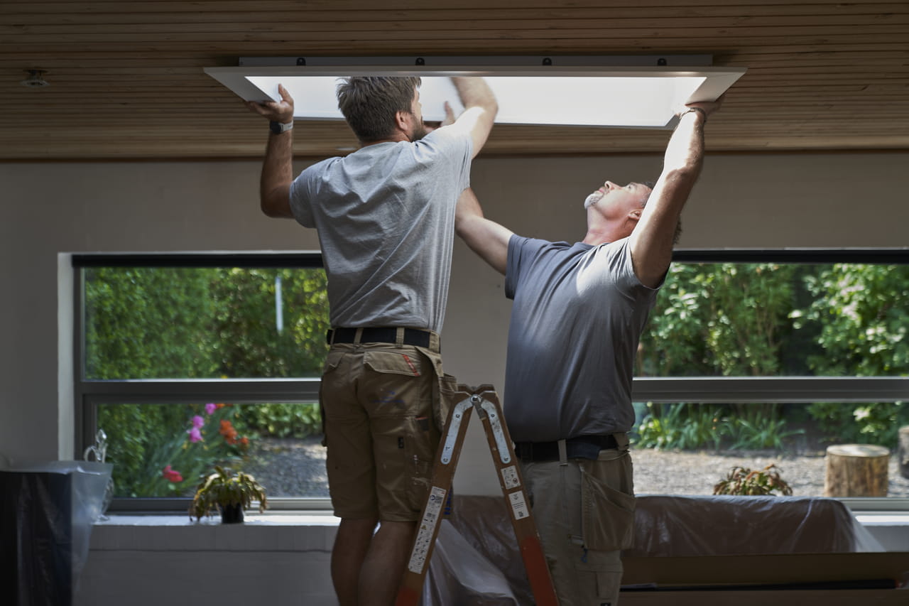 Two men installing a VELUX flat roof window