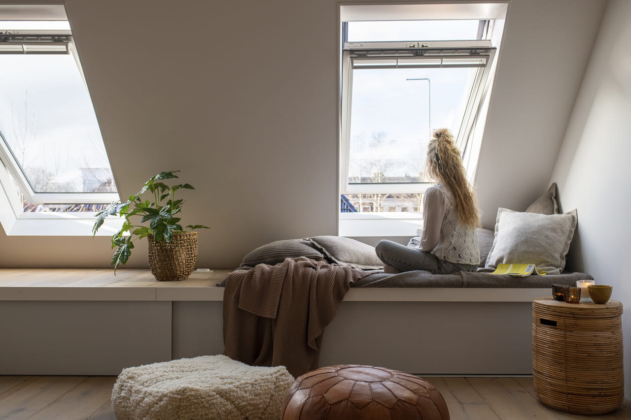 Woman sitting at her VELUX roof windows