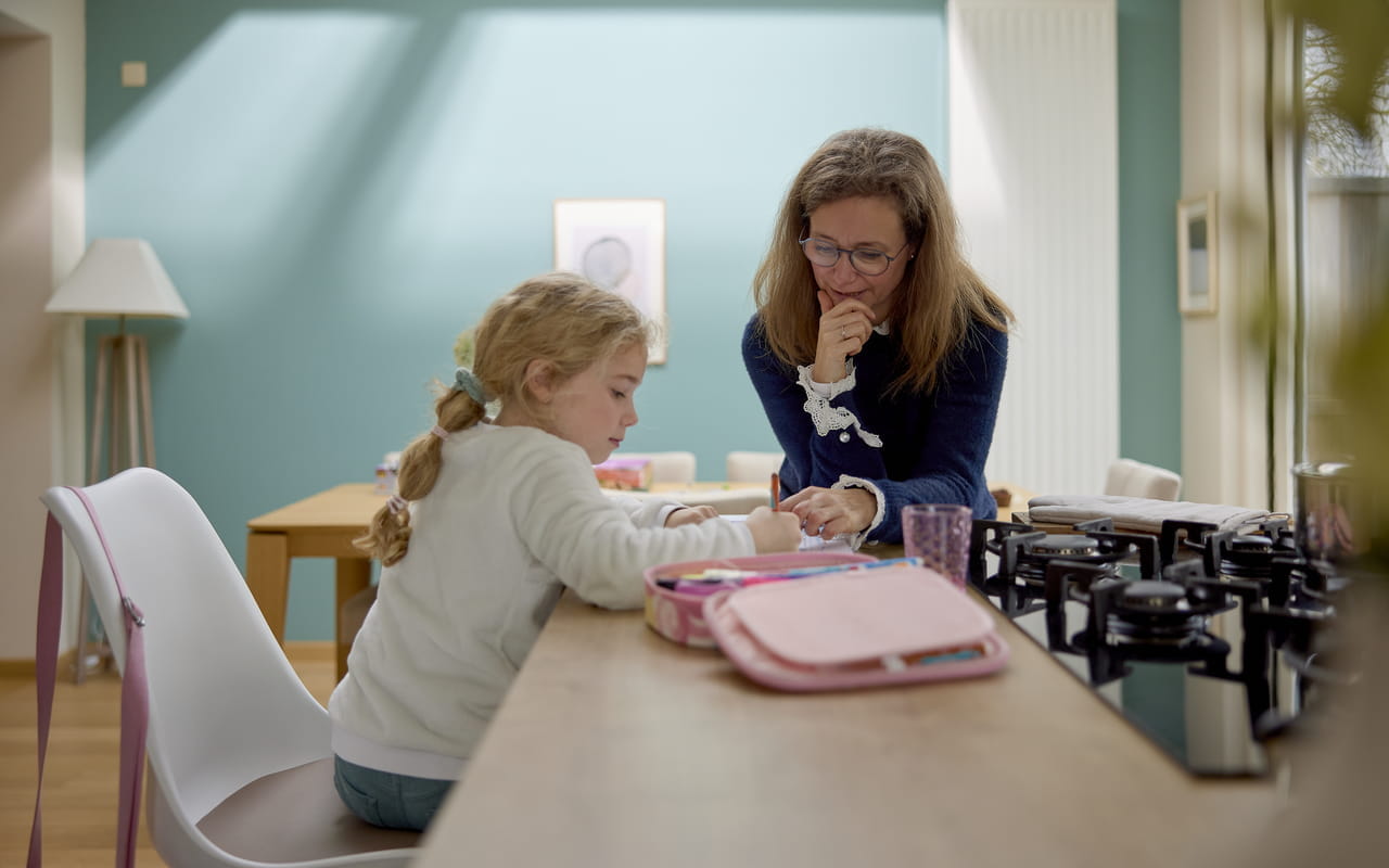 Mom and daughter sitting in their kitchen with VELUX windows